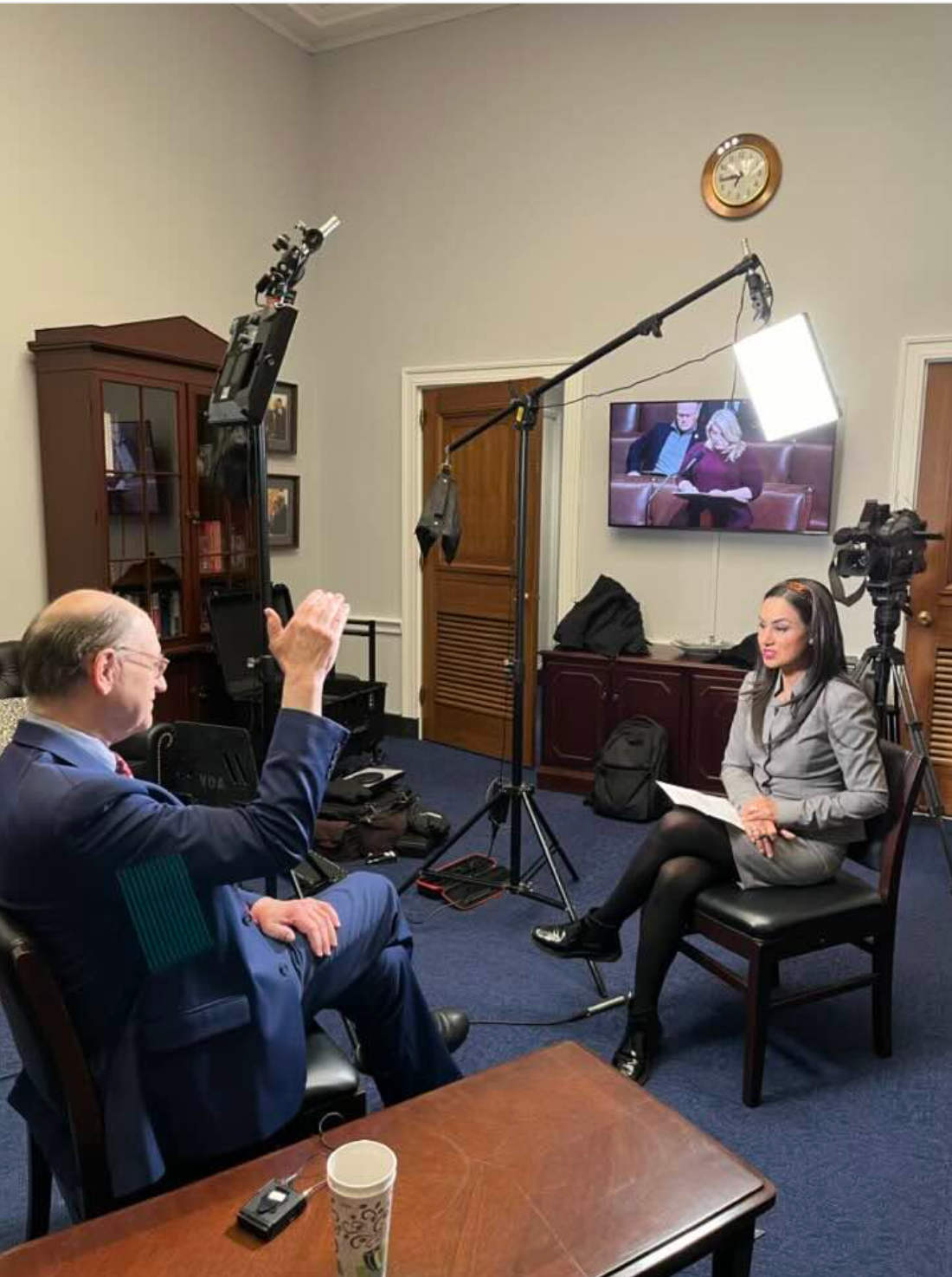 Reporter conducting a seated interview with production equipment